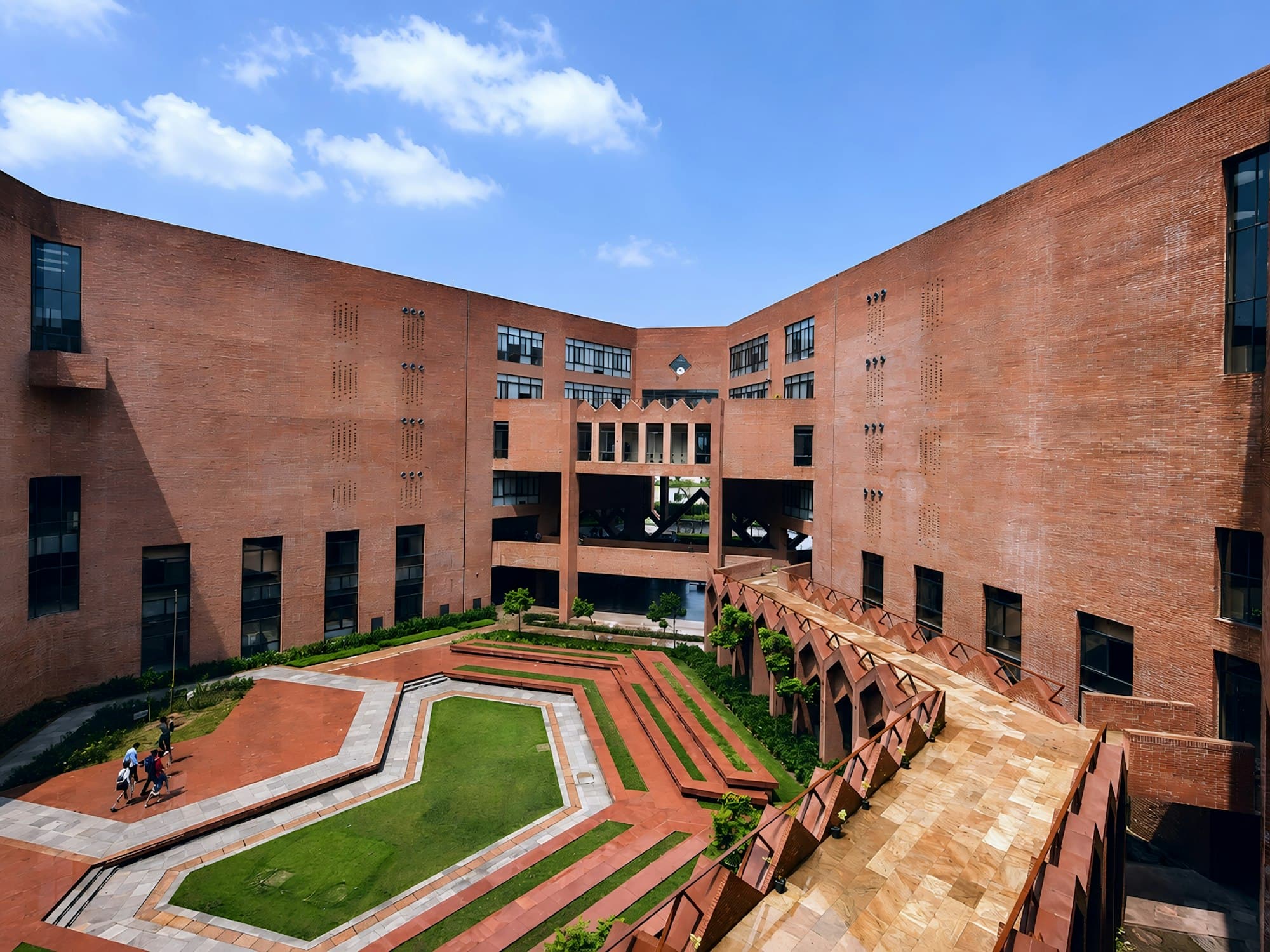 A brick university building around a landscaped courtyard under a blue sky